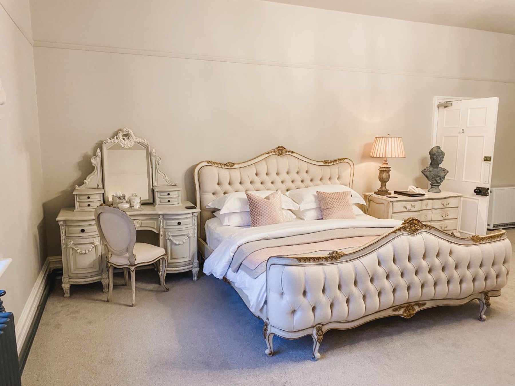 The Gainsborough bedroom at Glewstone Court, an ornate French-style bed, dressing table and chest of drawers