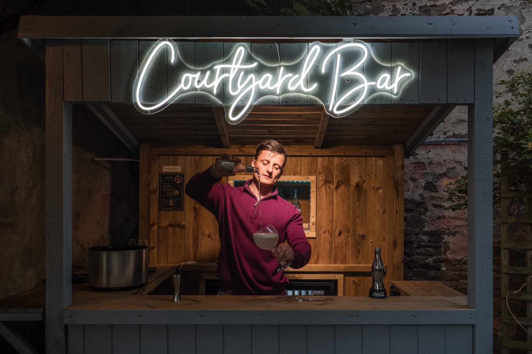 A cocktail being poured at the Courtyard Bar at Glewstone Court