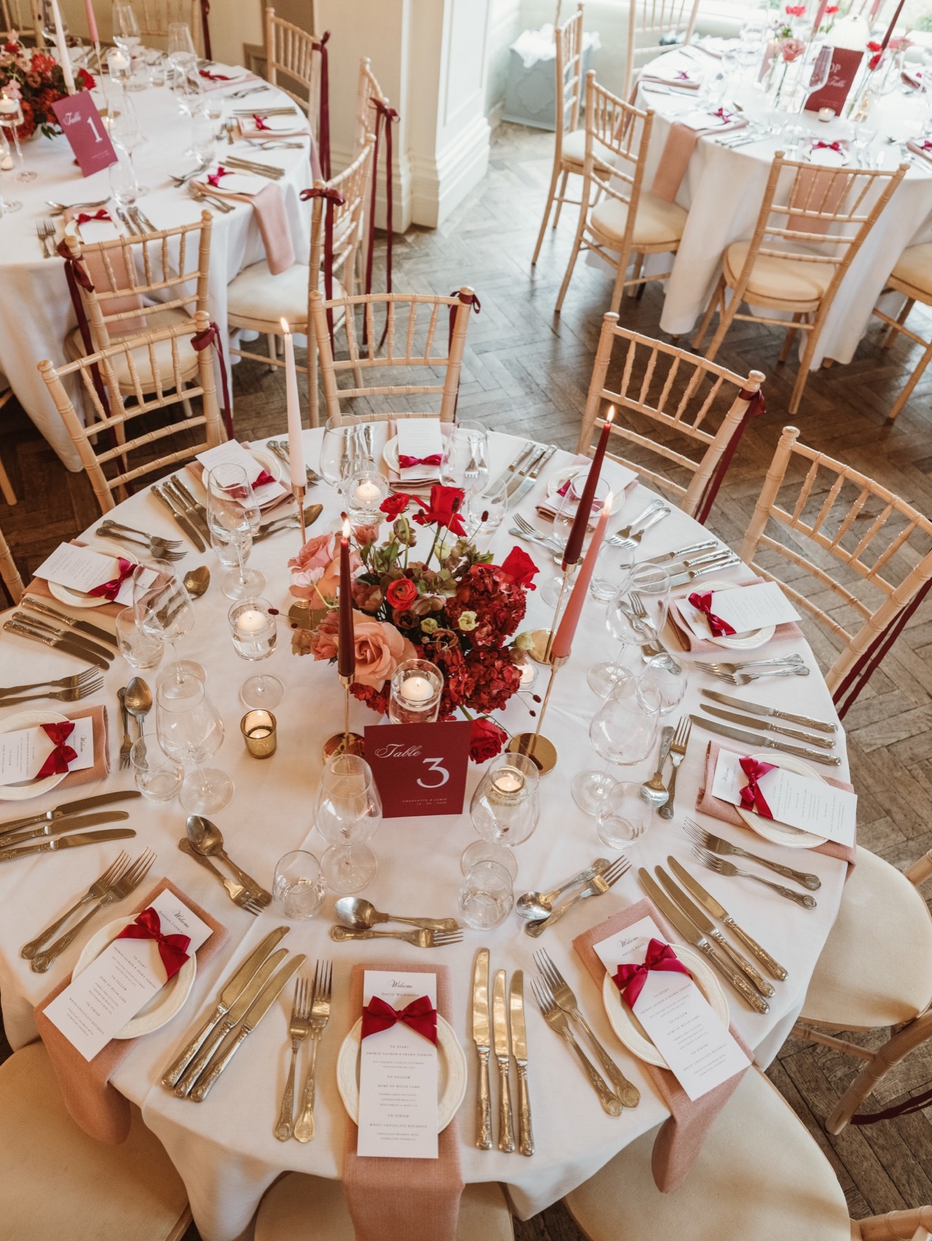 Round reception tables set across the connected dining rooms at Glewstone Court